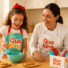 Niño MiniQuoker cocinando con su Quo-box de Quoking junto a un chef tutor en una cocina cálida y luminosa.